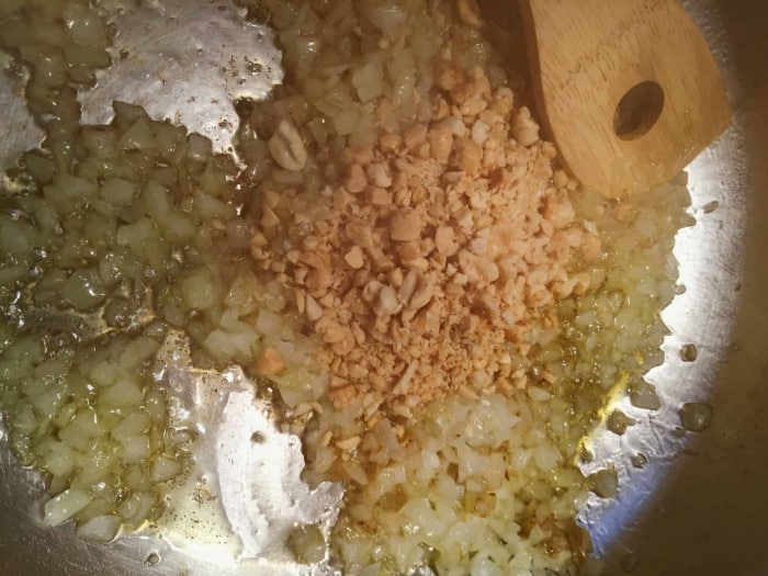 Zwiebeln und zerhackte Erdnüsse im Öl anbräunen