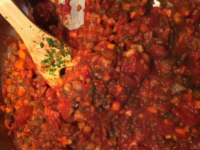 Salzen, pfeffern, Chiliflocken und Gemüsebrühe ergänzen und einkochen lassen.